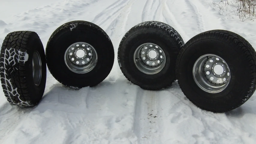 four new tires and snow wheels on a snowy road