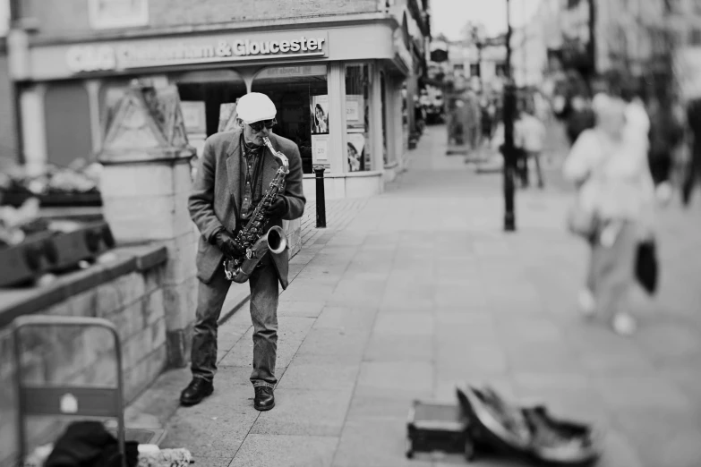 a man standing outside holding a saxophone on the street