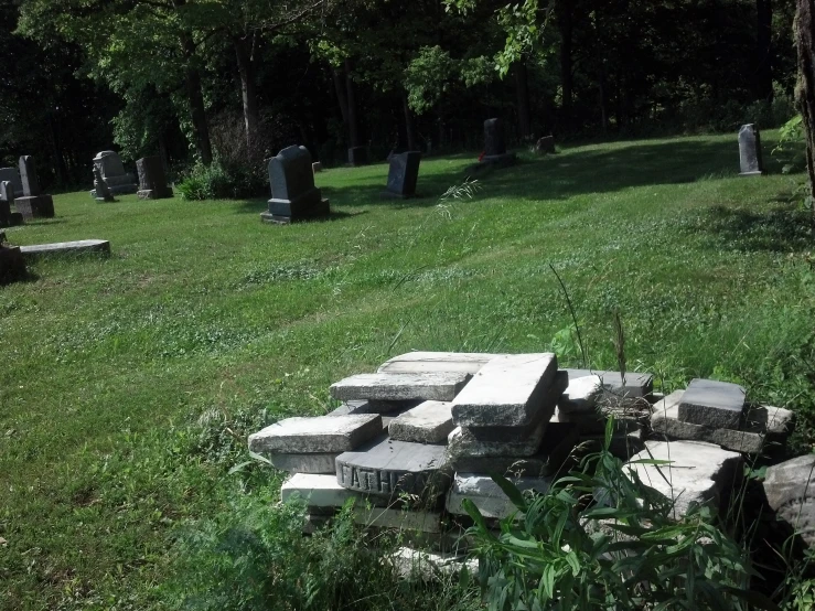 a cemetery with many stone pillars sitting in the grass