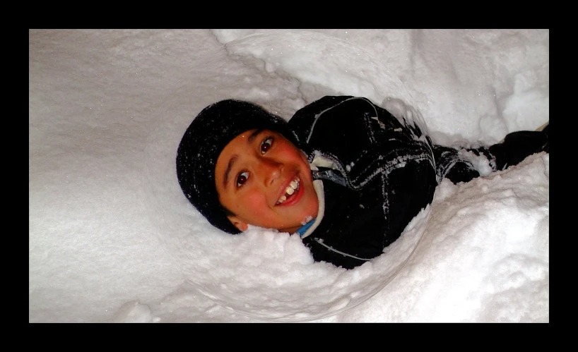 a  laying in the snow and smiling