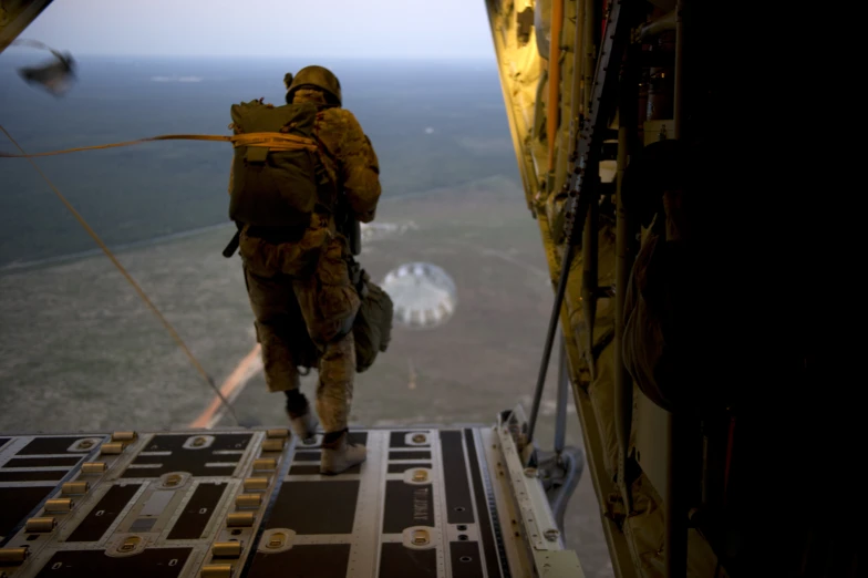 a soldier in uniform walking out of a small aircraft