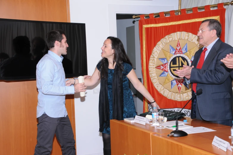 a man standing with two women at a table