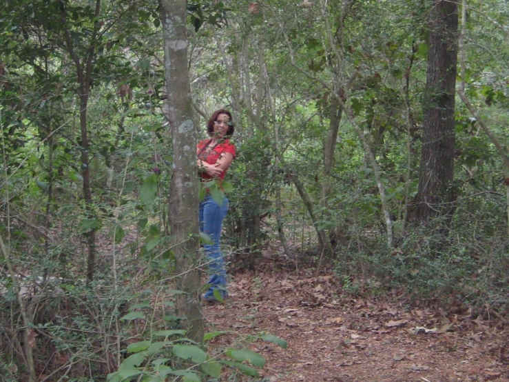 the young woman is walking through a wooded area