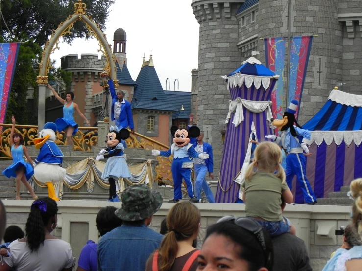 people are gathered around disney mouse in blue outfits