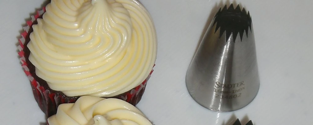 a plate with two cupcakes and a knife on top of it