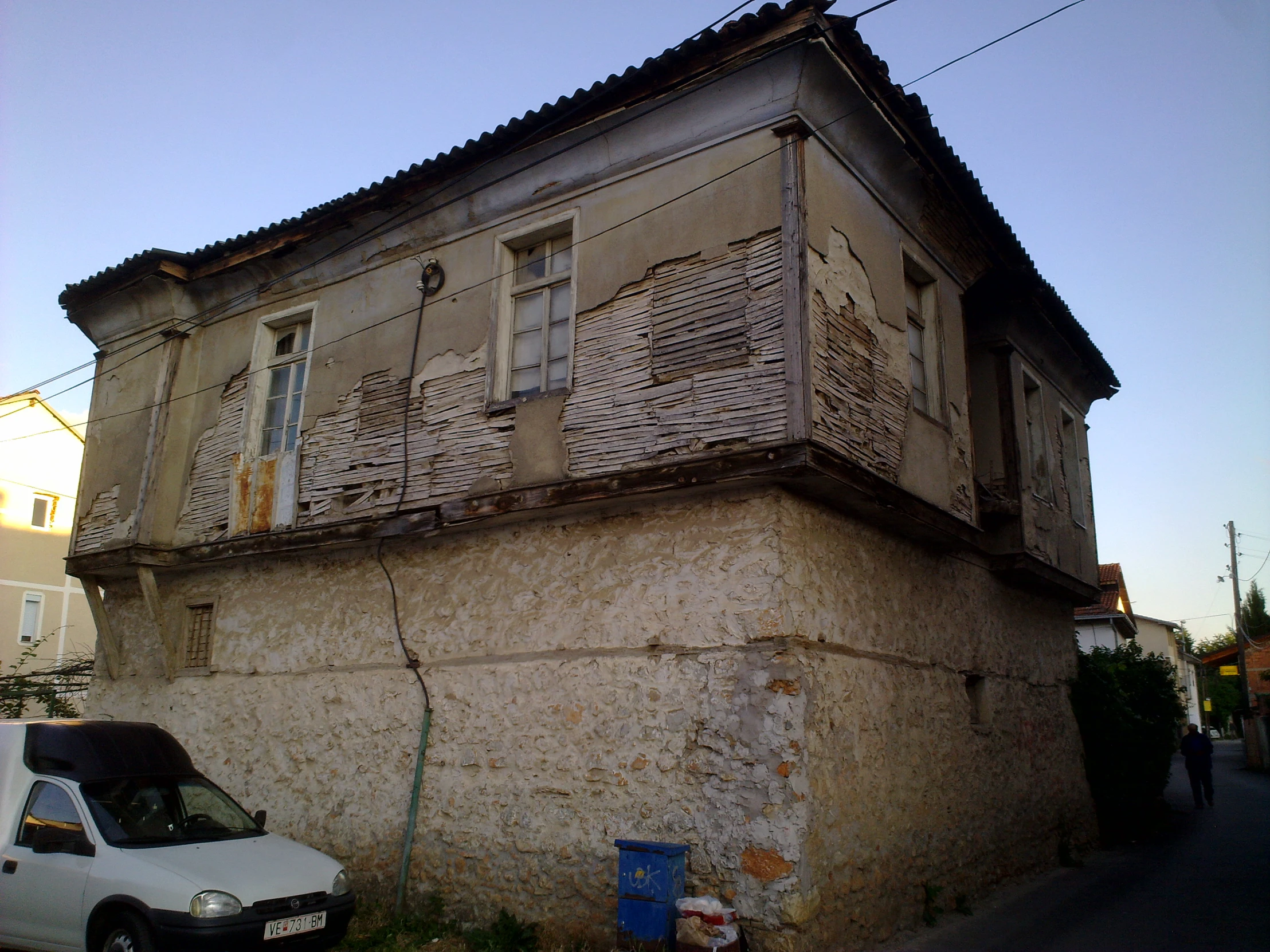 a van parked on the side of the road in front of an old building