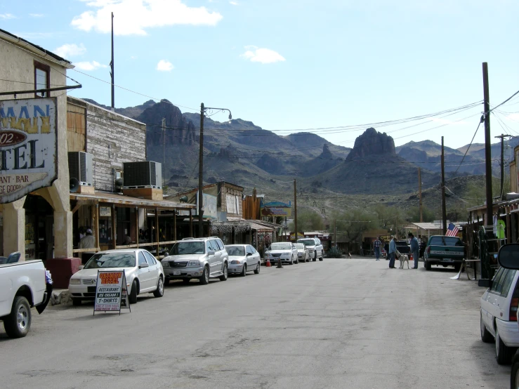 cars and pedestrians on the street in front of businesses