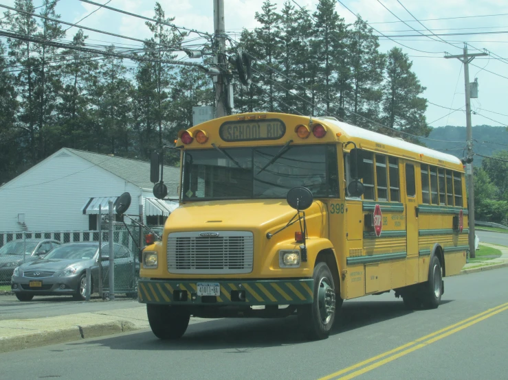 the yellow bus is traveling down the road