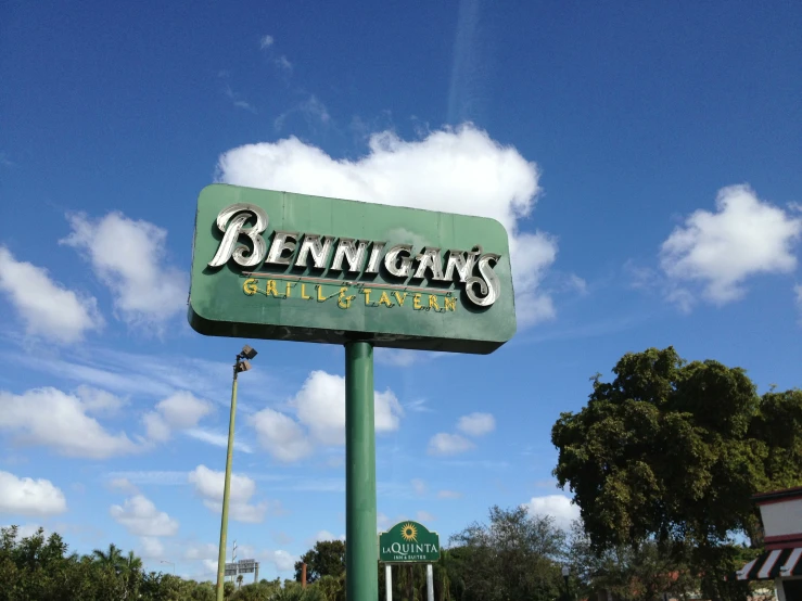 a sign is advertising bennigan's in a large parking lot