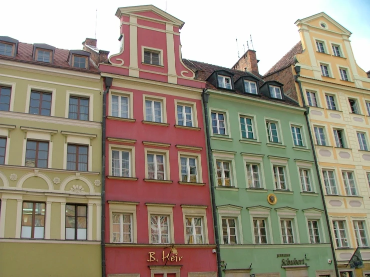 several buildings with a clock tower are in different colors