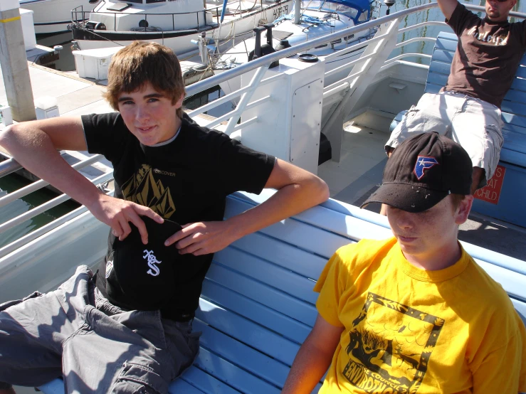 three s sitting on the bow of a boat looking at soing