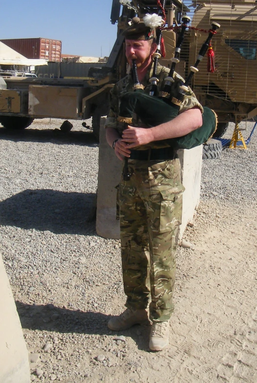 an older soldier standing next to a military truck