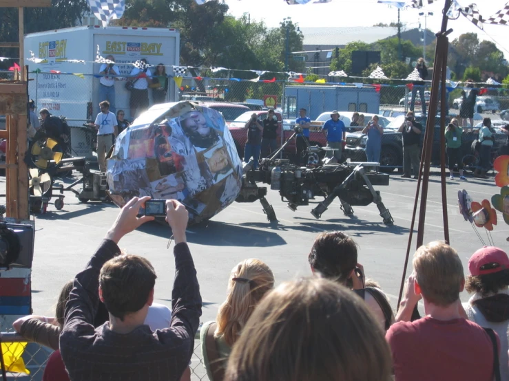 a group of people watching a group of large mechanical robots