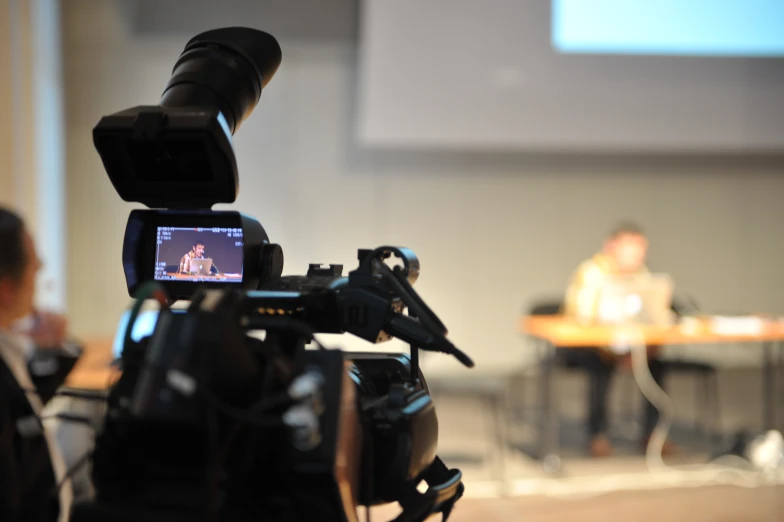 a video camera with the screen displaying two people in a room