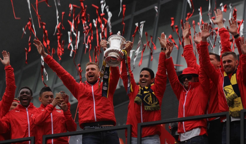 a group of men in red jackets holding up confetti