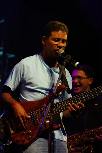 a man is holding a bass guitar and singing