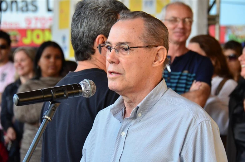 an older man standing in front of a microphone