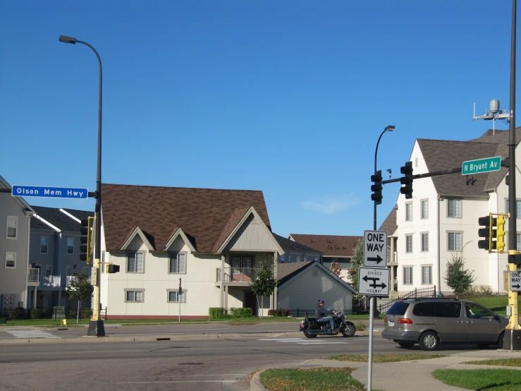 three buildings and several cars sit along the street