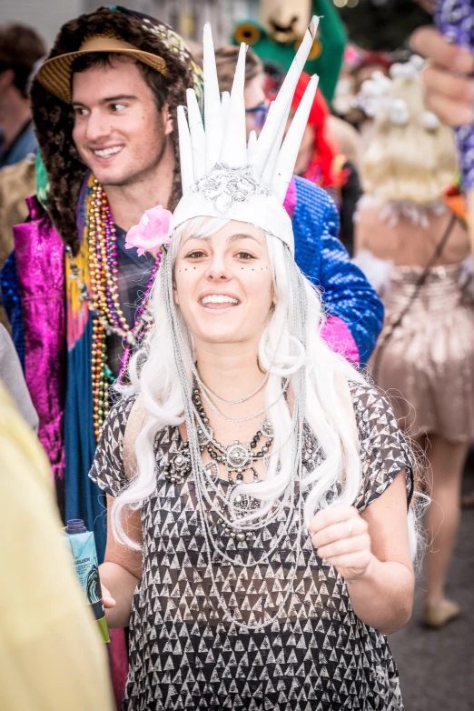 a woman in a white wig and headdress is smiling