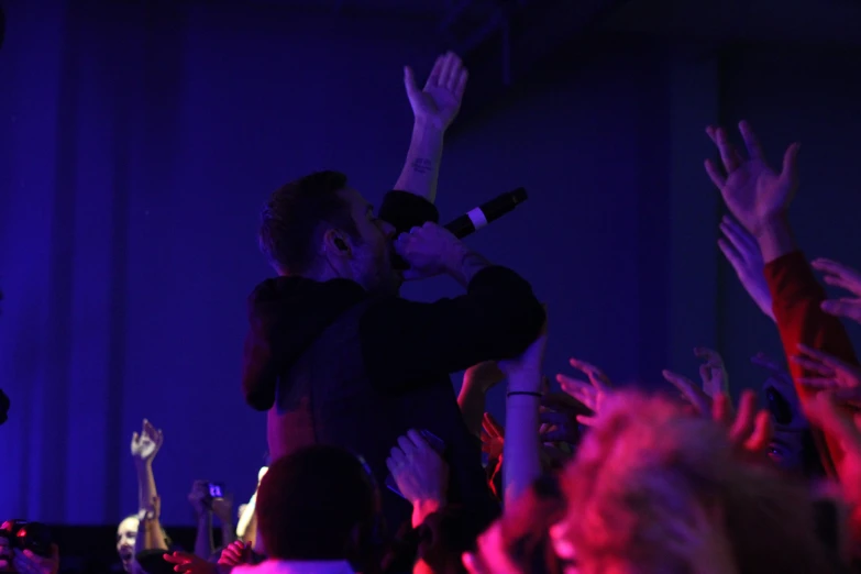 people standing and clapping while a musician plays on stage