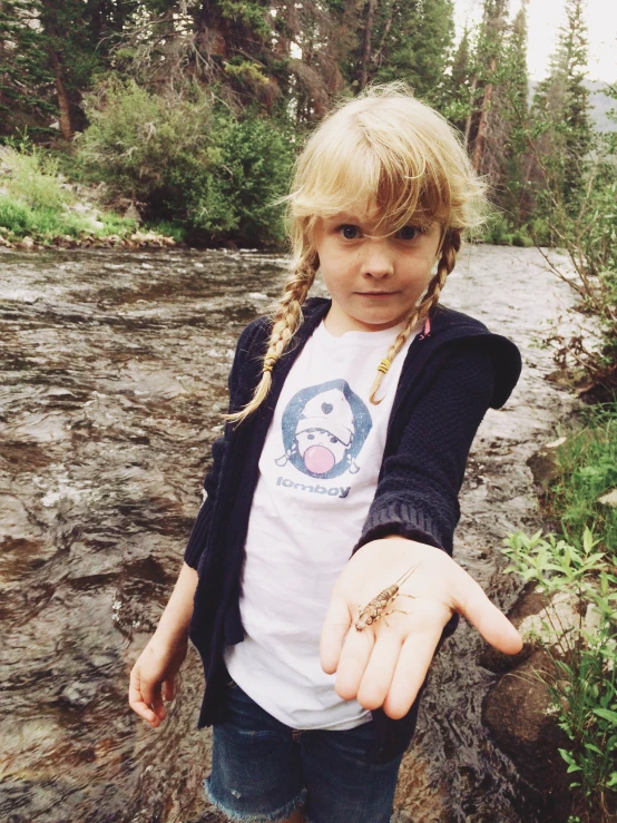 a girl with ids holds out her hand to stop the insect