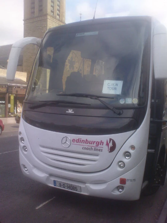 a white bus is sitting in a parking space