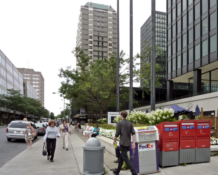 many people are on the sidewalk next to some buildings