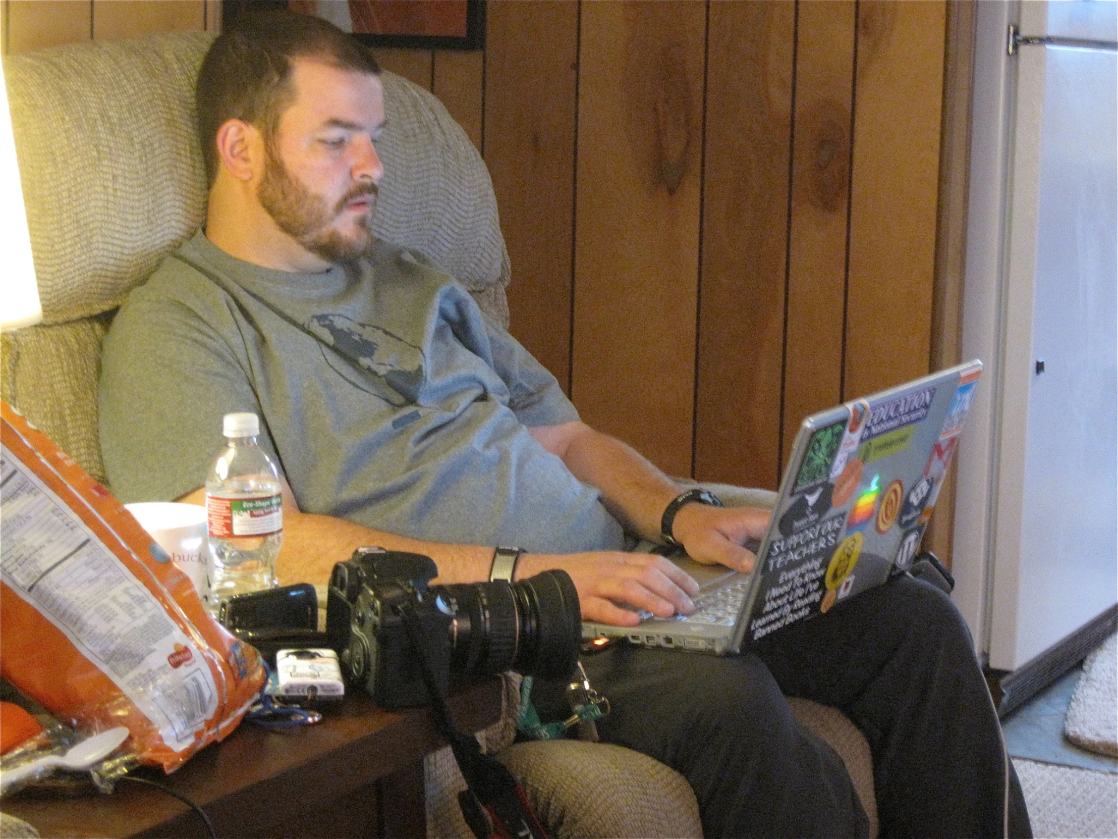 a man sitting down while looking at his computer