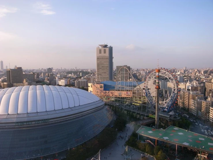 an aerial view of a city, with a roller coaster and lots of tall buildings