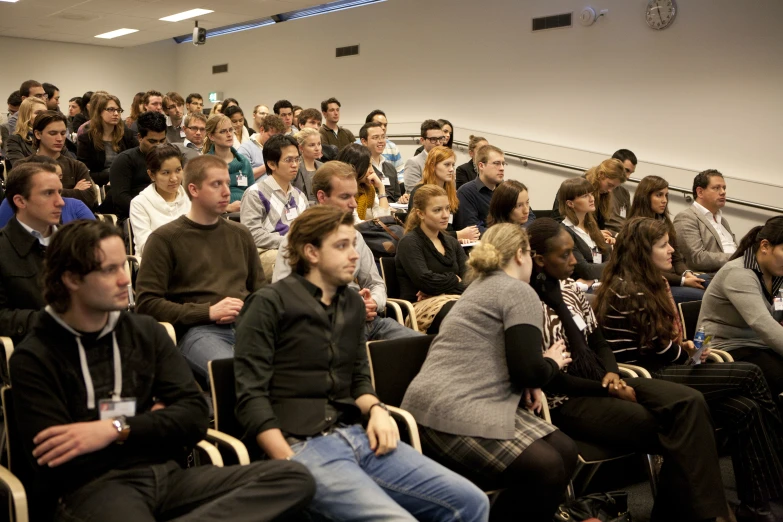 people sitting and standing at a conference in the center