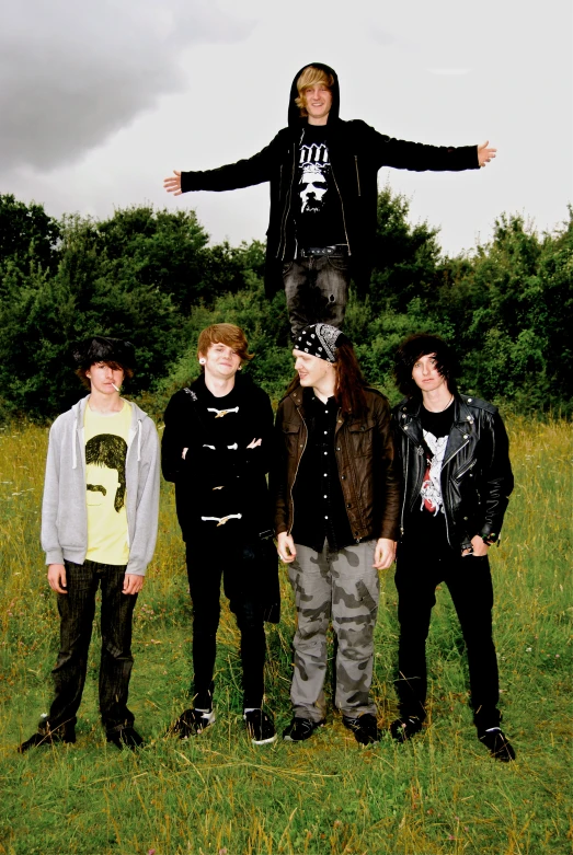 four guys are standing in front of an object