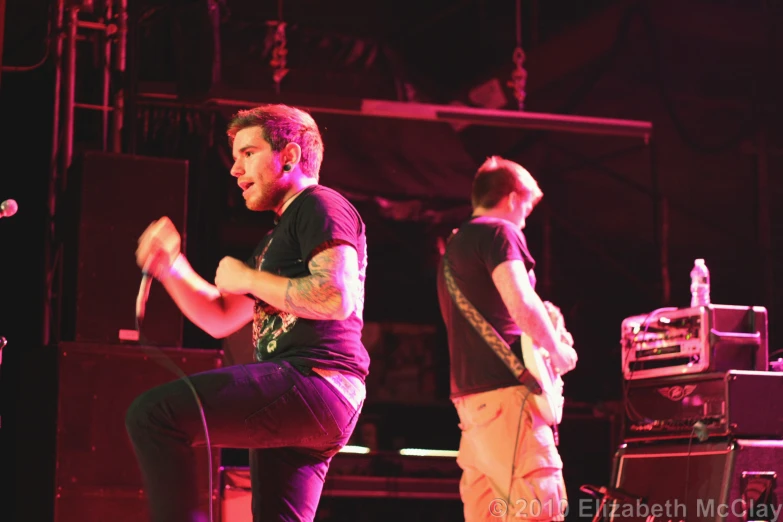 a man that is on a stool and playing guitar