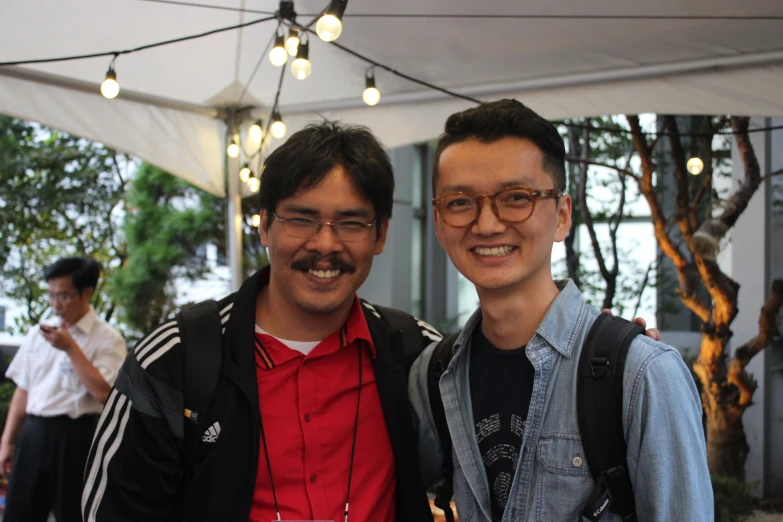 two guys with backpacks are smiling for a picture