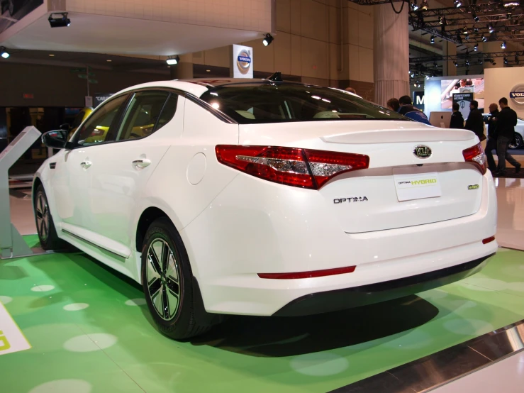 a white car sits on display in a building