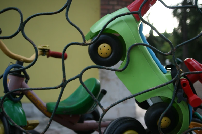 a 's tricycle is sitting outside and has rubber wheels