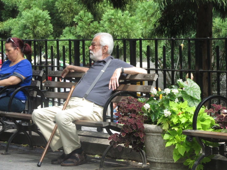 an old man and a woman on a park bench