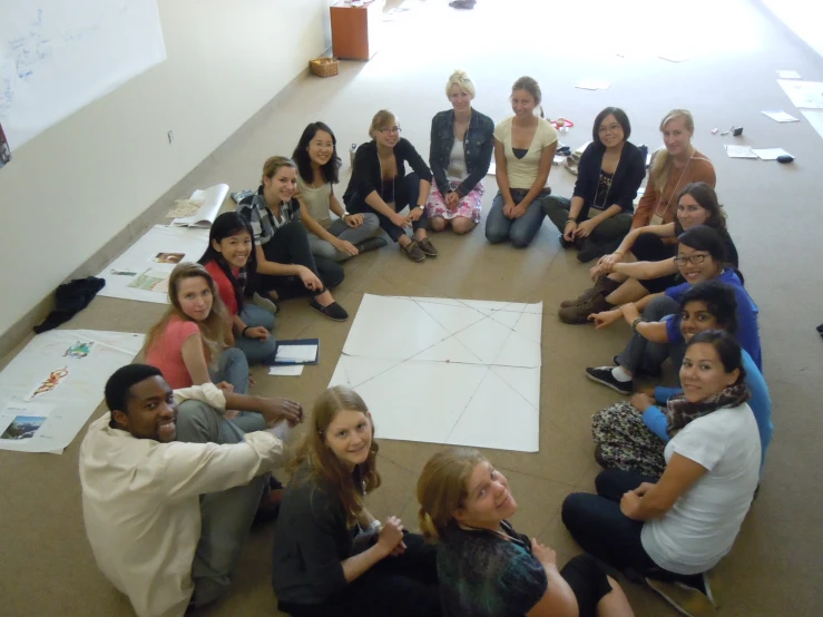 a group of people sitting in a circle on the floor