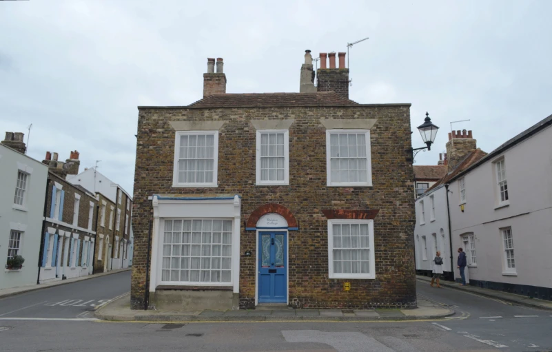 an old building with a blue door and white windows