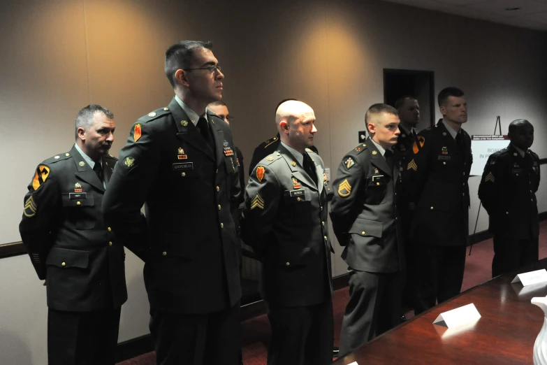 a row of uniformed military officers standing in a conference room