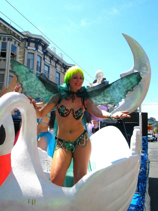 a woman in bikini top and swan costume on float