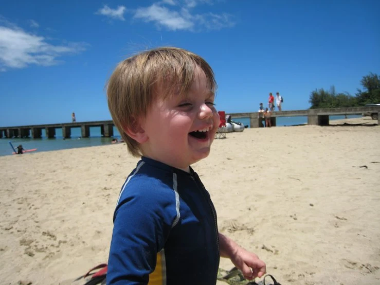 a  walking on a beach with his cameraman