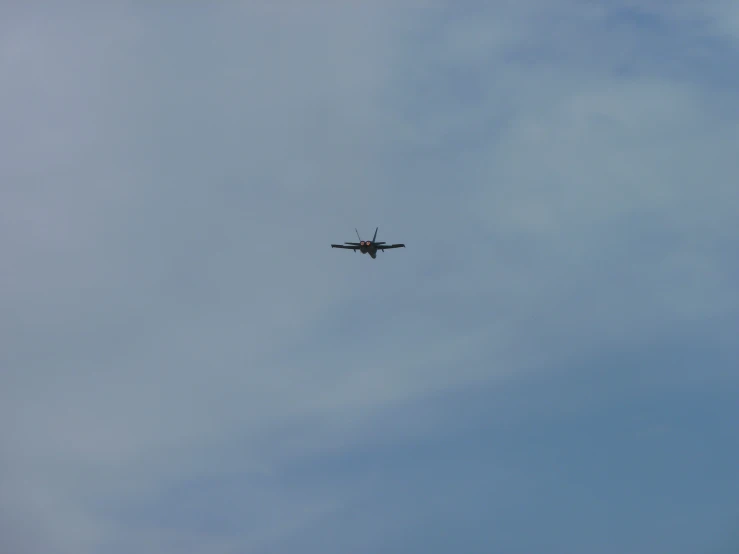 a plane flying through the blue sky on a cloudy day