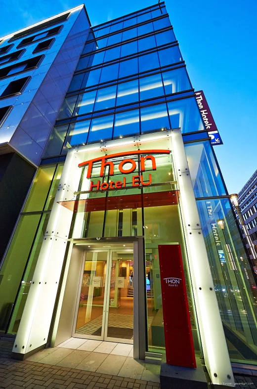 the facade of a tall glass building at night