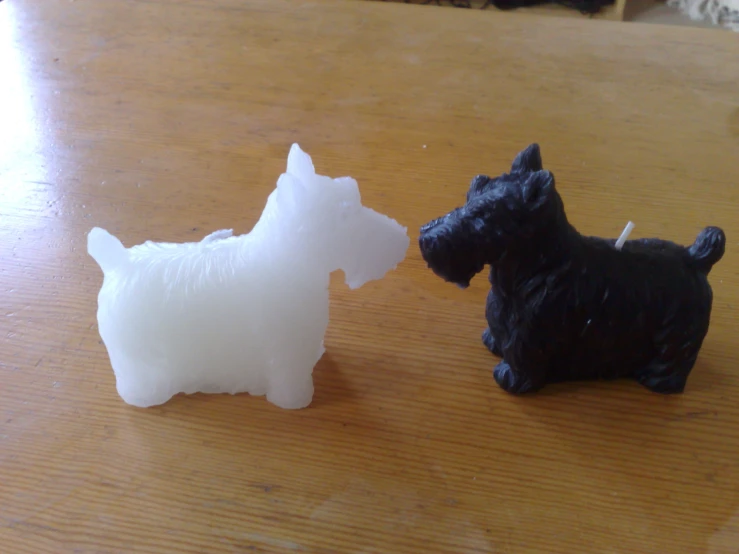 the small figurine of a dog stands next to a larger one