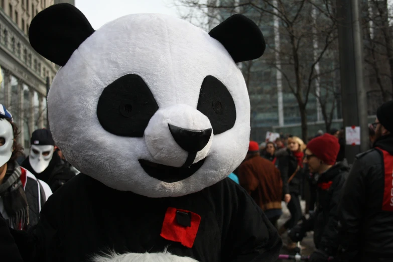 panda bear mask in the middle of crowd on street