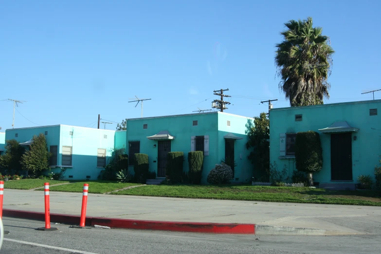 a blue house sitting next to red and white cones