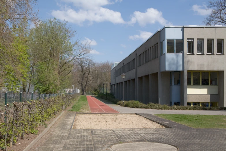 a road next to a cement building near trees