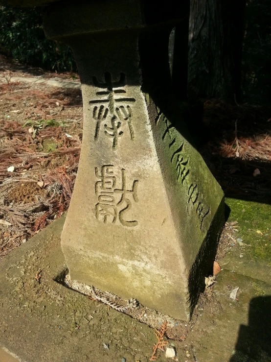 oriental writing etched into a stone structure at a park