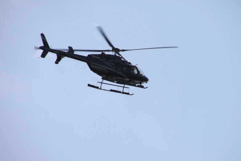 a helicopter flies through the blue sky on a sunny day