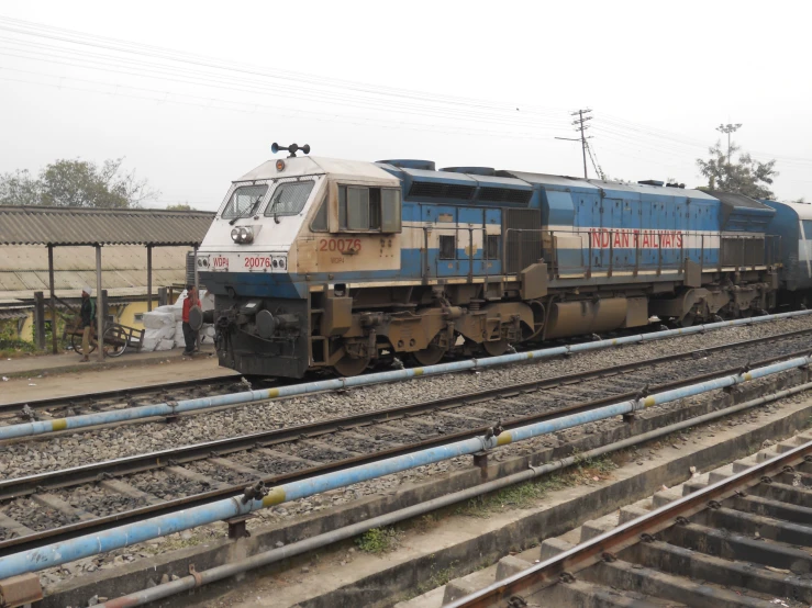 an old train parked on the tracks of an industrial building